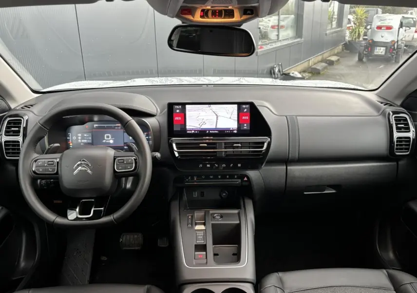 Vue intérieure frontale du tableau de bord noir du Citroën C5 Aircross 2025 avec écran tactile central et volant multifonction.