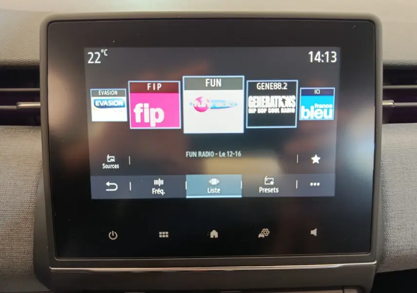 Écran tactile central de la Renault Clio 2024 affichant les stations radio, vue frontale rapprochée.