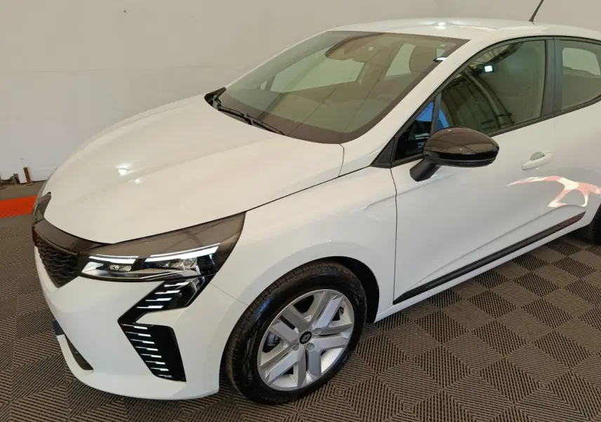Renault Clio 2024 blanche vue 3/4 avant droit, avec phares LED distinctifs et rétroviseurs noirs.