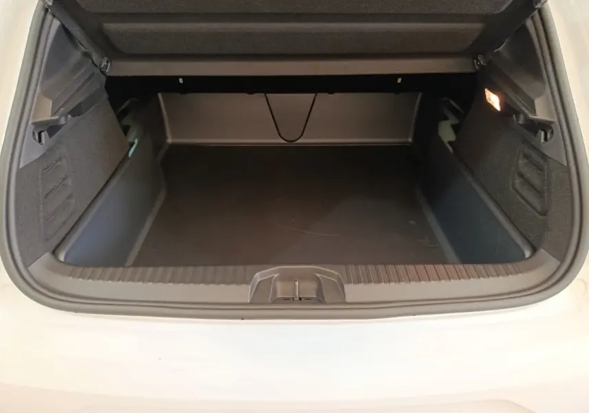 Coffre ouvert vu de l'arrière d'une Renault Clio blanche 2024, montrant un espace de chargement vide et propre.