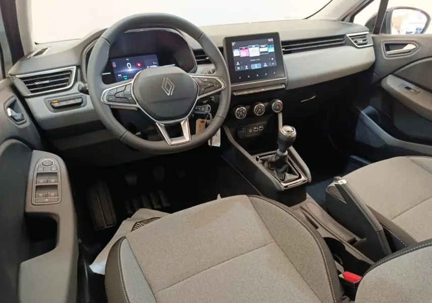 Vue intérieure avant droite de la Renault Clio 2024 avec tableau de bord numérique et volant multifonctions cuir synthétique.