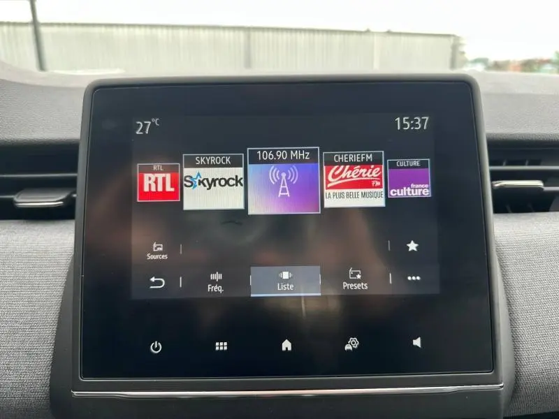 Écran tactile central de la Renault Clio 2025 affichant les stations radio, dans un intérieur gris.