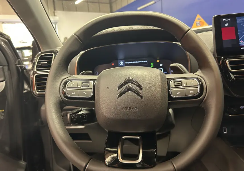 Volant en cuir noir de Citroën C5 Aircross 2025 avec commandes intégrées et tableau de bord numérique visible.