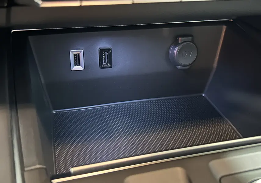 Prise 12V et deux ports USB en gros plan dans le compartiment central d’un Citroën C5 Aircross gris platinium 2025.