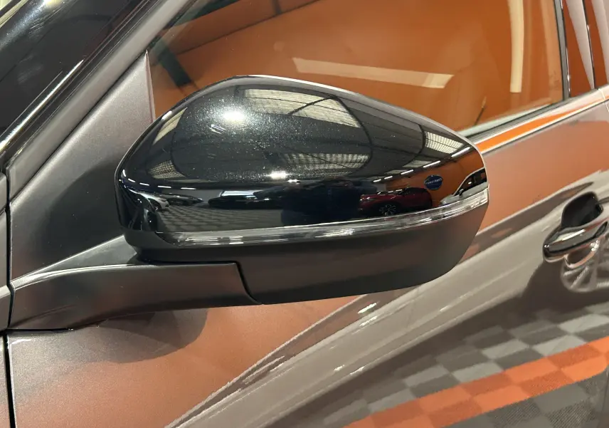 Rétroviseur noir brillant côté gauche sur porte gris platinium d'un Citroën C5 Aircross 2025 en intérieur showroom.
