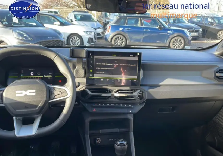 Vue intérieure du tableau de bord du Dacia Duster noir 2026, avec écran tactile central et volant multifonction.