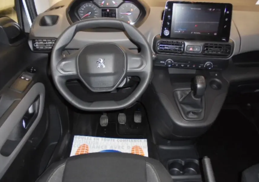 Vue intérieure avant du Peugeot Rifter 2020, tableau de bord avec volant compact, écran tactile et levier de vitesses manuel.