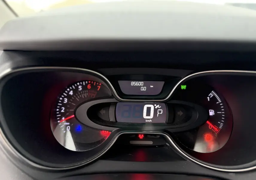 Vue rapprochée du tableau de bord numérique du Renault Captur rouge 2017, affichant 85 600 km et vitesse à 0 km/h.