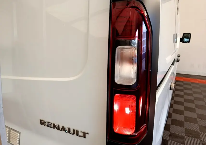 Gros plan sur le feu arrière droit et le logo Renault d’un fourgon blanc Renault Trafic L1H1 2021, vue arrière côté droit.
