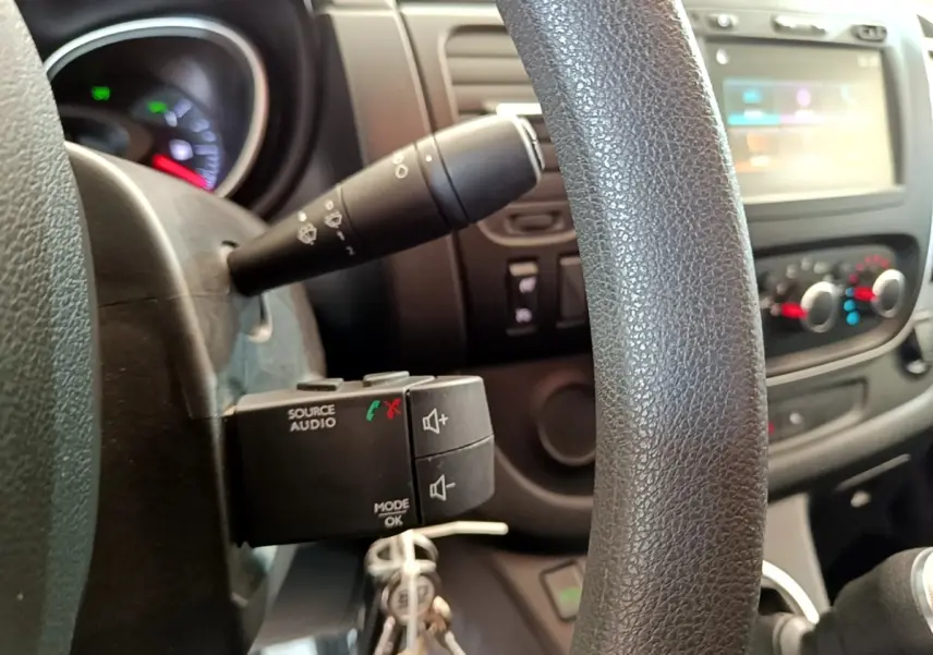 Détail du volant et commandes audio sur le tableau de bord intérieur du Renault Trafic Fourgon blanc, version 2021.