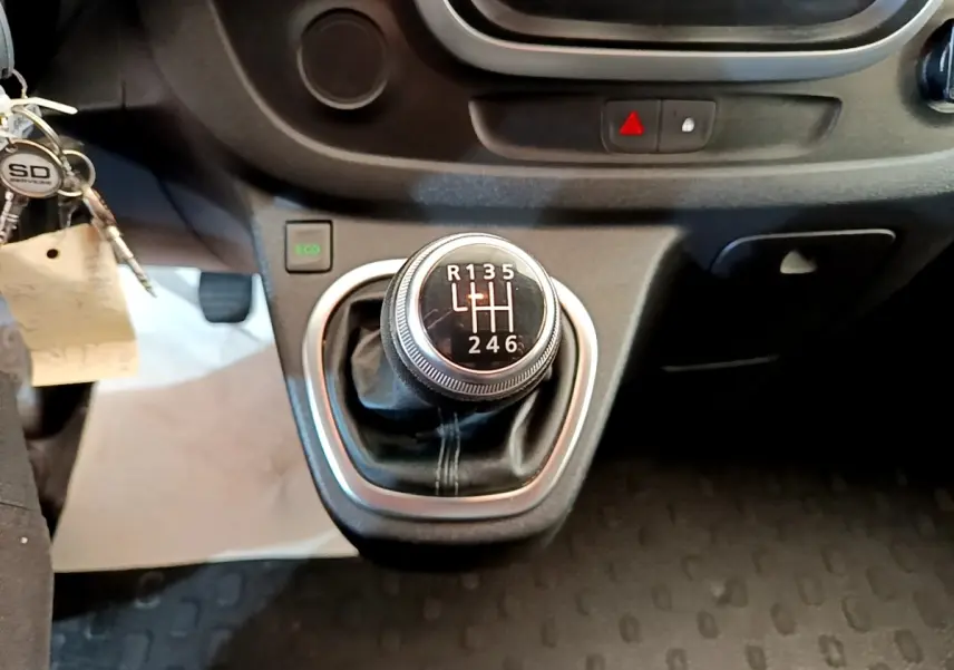 Gros plan sur le levier de vitesses manuel du Renault Trafic Fourgon blanc, avec bouton Eco et tableau de bord partiel.