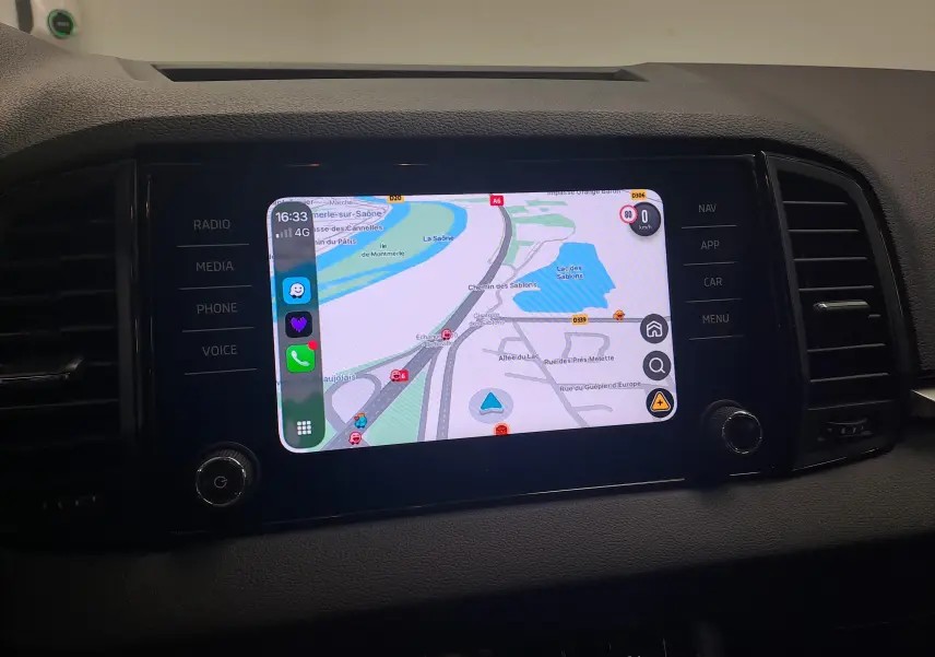 Écran tactile central du Skoda Karoq 2025 affichant la navigation, entouré de commandes noires mates.