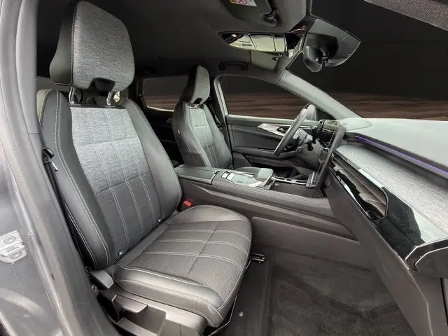 Vue intérieure côté conducteur du Renault Austral gris Casiopee, montrant les sièges en tissu gris et la planche de bord moderne.