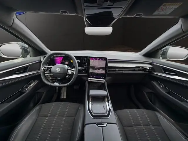 Vue intérieure avant du Renault Austral E-Tech gris Casiopee, tableau de bord numérique et écran tactile central vertical.