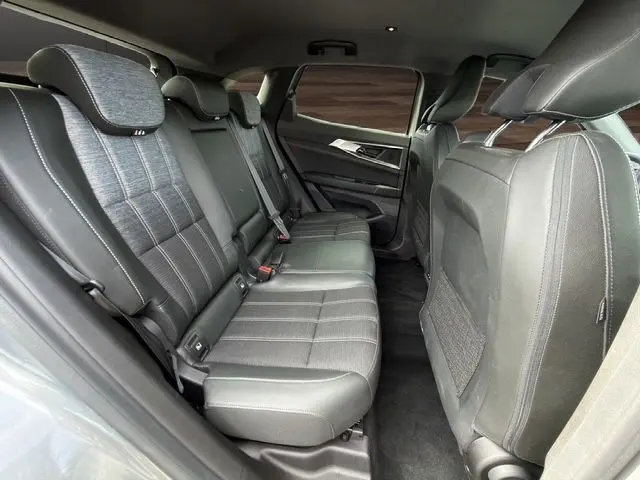 Vue intérieure arrière côté gauche du Renault Austral gris Casiopee, montrant la banquette mixte tissu et cuir gris avec appuis-tête réglables.