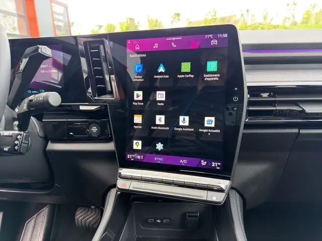 Vue rapprochée de la console centrale intérieure du Renault Austral gris Casiopee, avec écran tactile vertical multimédia allumé.