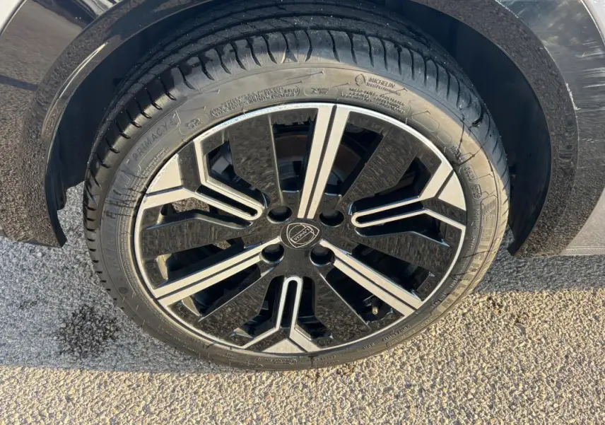 Gros plan sur la jante avant droite 17 pouces noire et argentée d'une Lancia Ypsilon gris 2025.