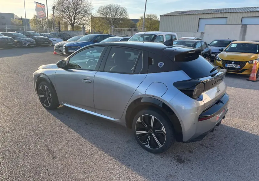 Vue 3/4 arrière droite d'une Lancia Ypsilon gris métallisé avec toit noir et jantes 17 pouces, stationnée en extérieur.