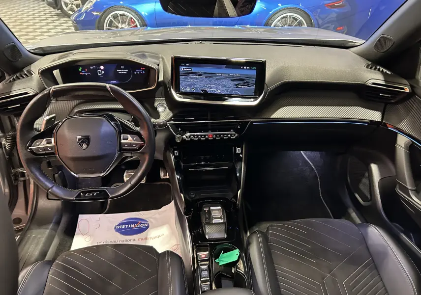 Vue intérieure avant du Peugeot 2008 GT Pack gris Artense, mettant en valeur le tableau de bord numérique et l'écran central tactile.