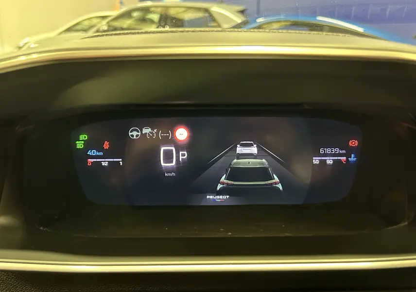 Affichage numérique du tableau de bord du Peugeot 2008 avec caméra 360° et indicateurs de vitesse et distance.