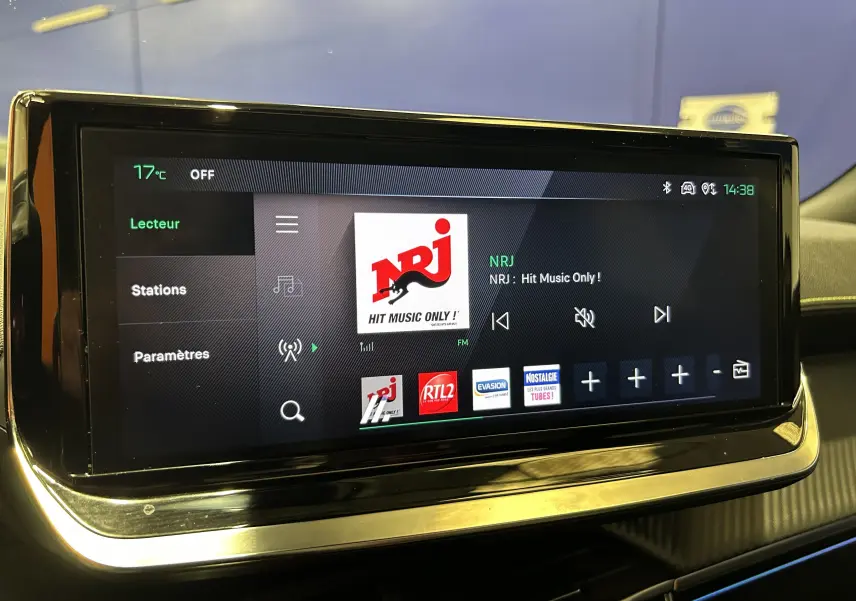 Écran tactile central du Peugeot 2008 2024 affichant la radio NRJ avec interface moderne et fond noir.