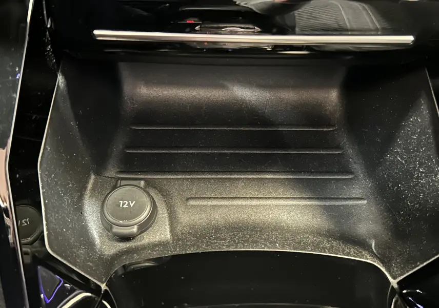 Gros plan sur la prise 12V et le rangement central noir du Peugeot 2008 2024, finition GT Pack.