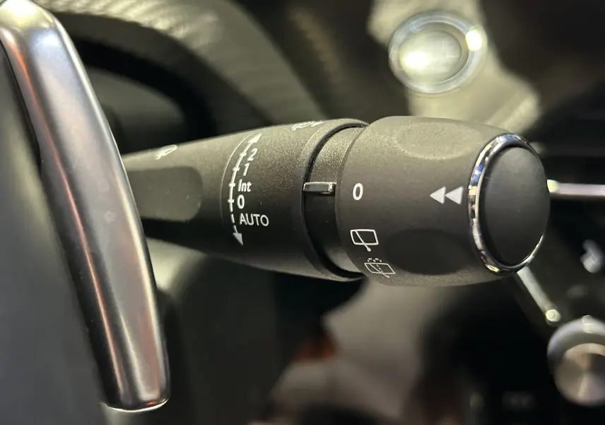Gros plan sur la commande d’essuie-glace du Peugeot 2008 gris Artense, avec détails des réglages automatiques et manuels.