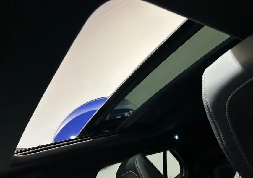 Vue intérieure du toit ouvrant panoramique et siège avant en cuir du Peugeot 2008 Gris Artense 2024.