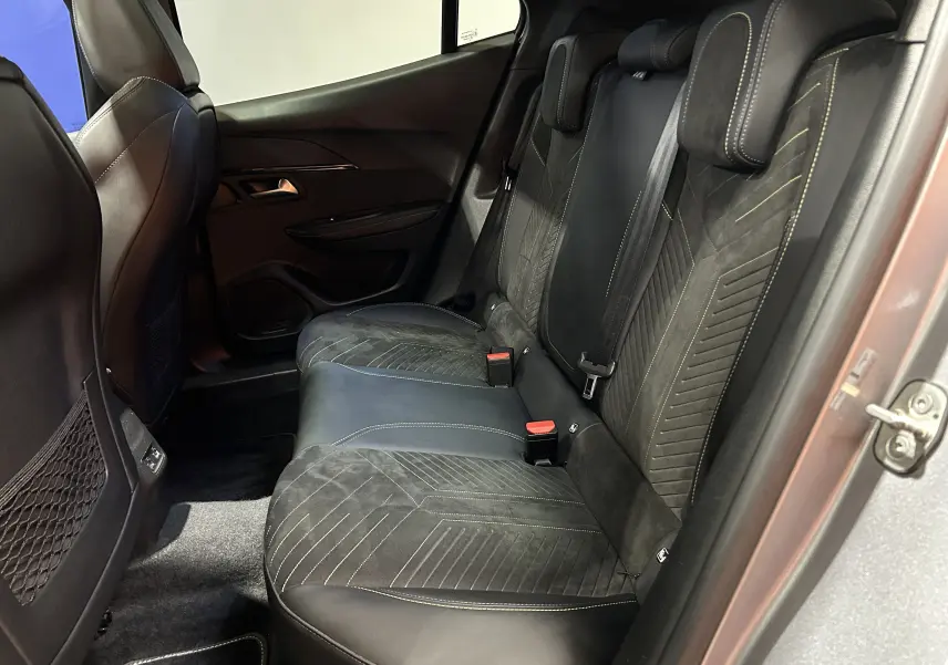 Vue intérieure côté droit des sièges arrière en cuir et alcantara noirs du Peugeot 2008 Gris Artense, avec surpiqûres contrastantes.