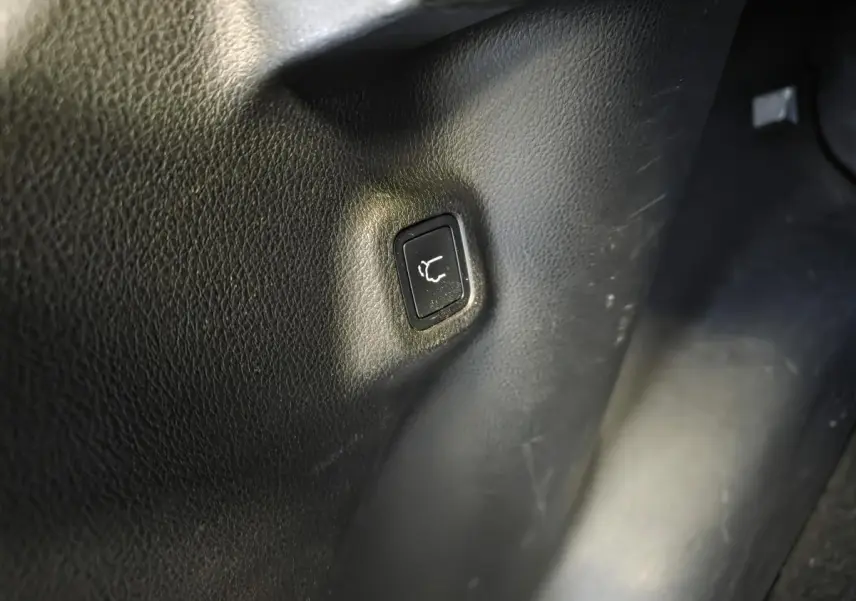 Bouton de hayon électrique intégré dans l'habillage noir intérieur du Jeep Compass Trailhawk hybride rechargeable.