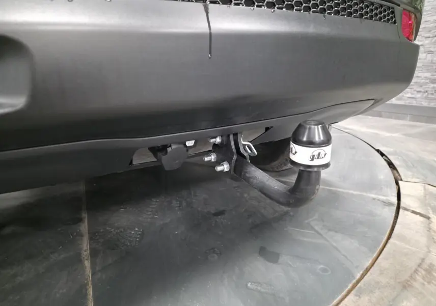 Gros plan sur l'attelage fixe noir sous le pare-chocs arrière gris du Jeep Compass Trailhawk 2020.