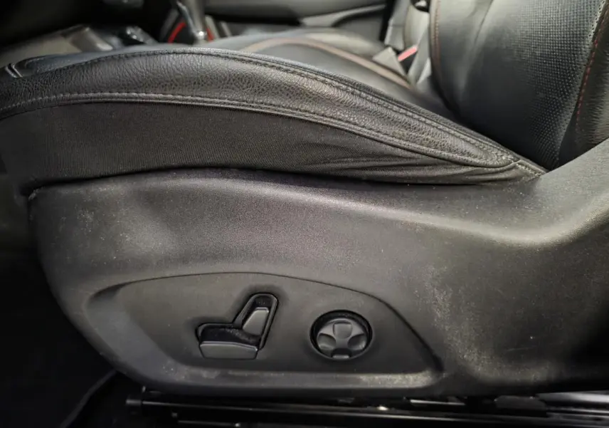 Gros plan sur les commandes électriques du siège conducteur en cuir noir du Jeep Compass Trailhawk gris.