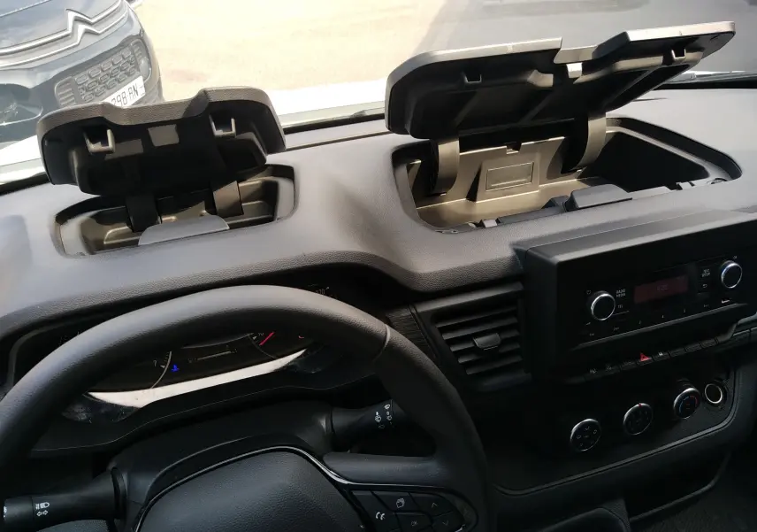 Vue intérieure du tableau de bord du Renault Trafic Fourgon blanc 2024, avec deux compartiments de rangement ouverts.