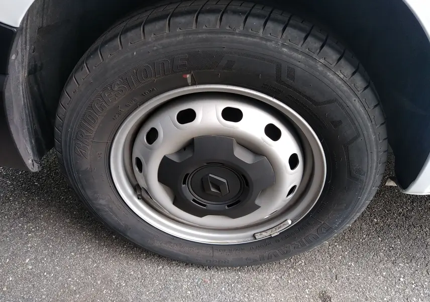 Gros plan sur la roue avant droite du Renault Trafic Fourgon blanc, mettant en valeur la jante acier et le pneu Bridgestone.