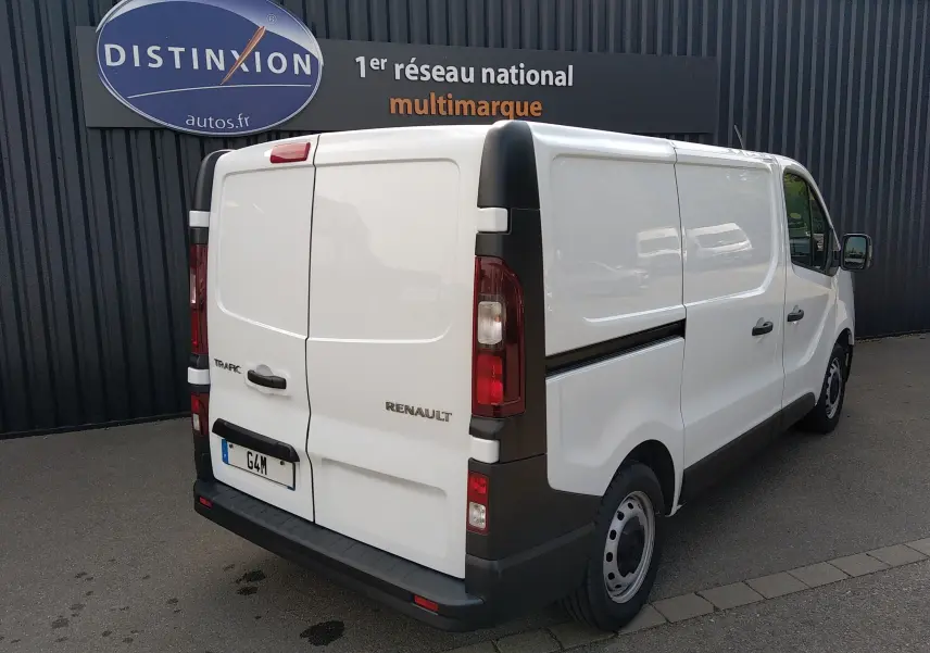 Renault Trafic Fourgon blanc en 3/4 arrière droit, avec portes arrière fermées et jantes acier noires.