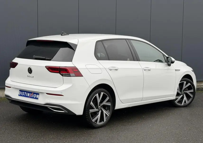Volkswagen Golf VIII blanche vue 3/4 arrière droit avec jantes alliage 18 pouces et vitres arrière surteintées.