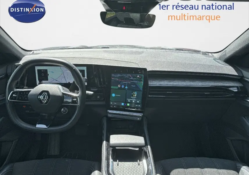 Vue intérieure avant du Renault Austral 2024, tableau de bord moderne avec écran tactile central et volant multifonction noir.