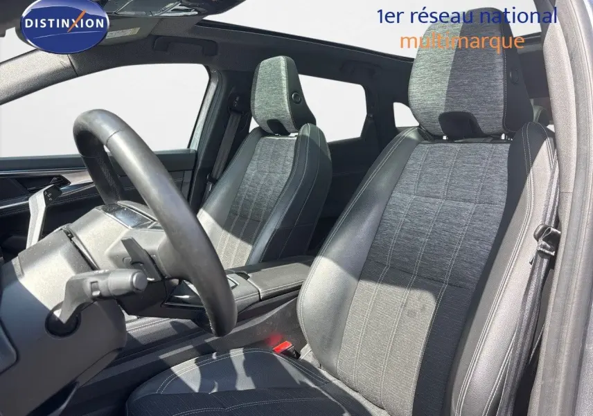 Vue intérieure des sièges avant en tissu gris et cuir noir du Renault Austral 2024, avec volant partiellement visible.