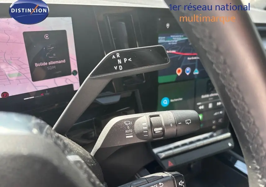 Vue rapprochée du levier de vitesses automatique et des commandes au volant d’un Renault Austral gris schiste métal 2024.