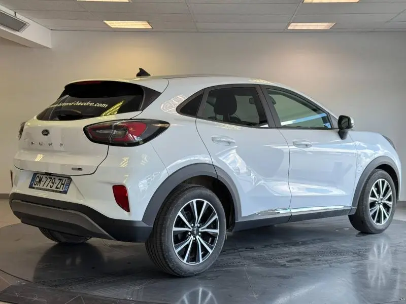 Vue 3/4 arrière droite d'un Ford Puma blanc glacier avec jantes noires et vitres arrière surteintées.