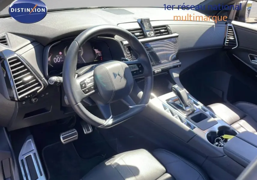 Vue intérieure côté conducteur du DS7 2024 noir métal, mettant en valeur le volant cuir et la console centrale moderne.