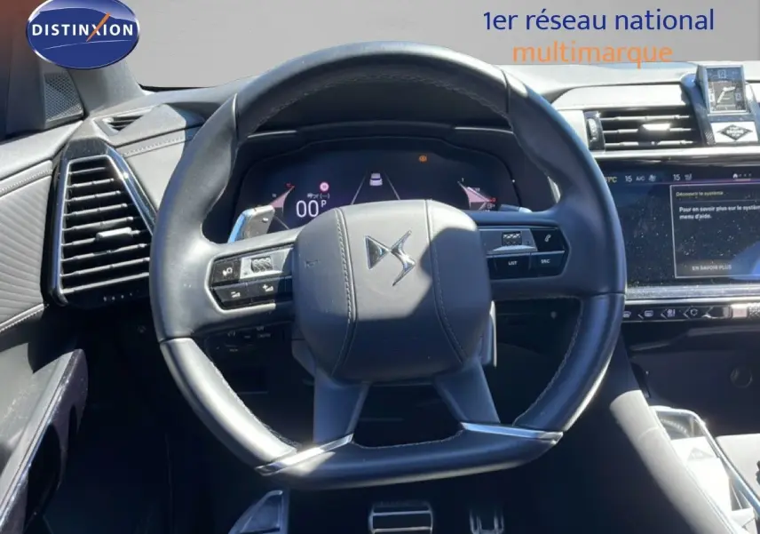 Vue rapprochée du volant DS noir cuir du DS7 2024, avec tableau de bord numérique et écran tactile visible à droite.