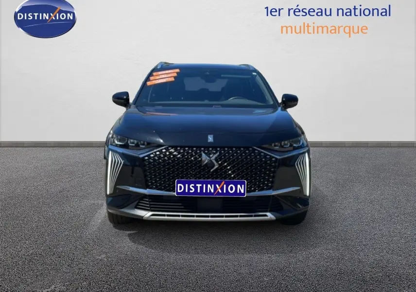 Vue frontale d’un DS7 noir métal 2024 avec calandre distinctive et feux LED verticaux allumés.