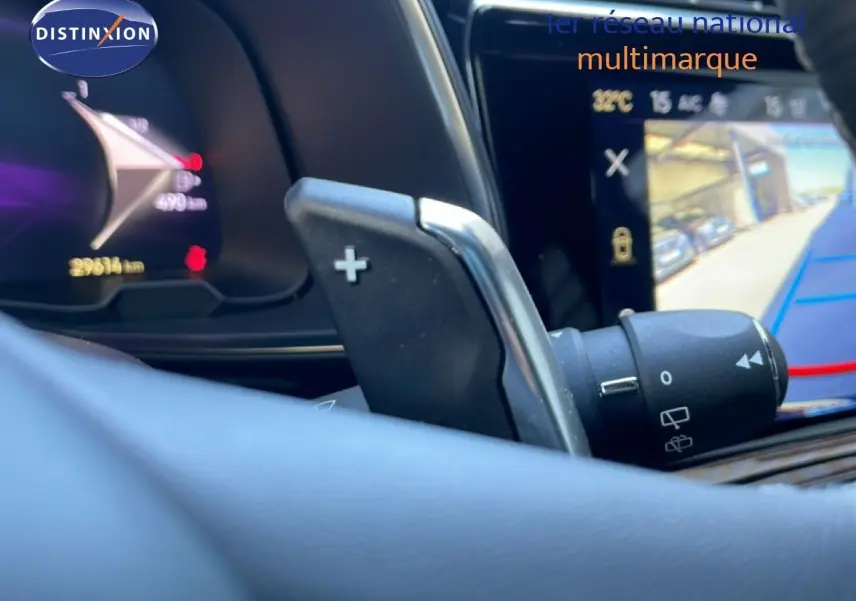 Gros plan sur la commande de palette de vitesse au volant du DS7 2024 noir métal, avec écran tactile et tableau de bord numérique.