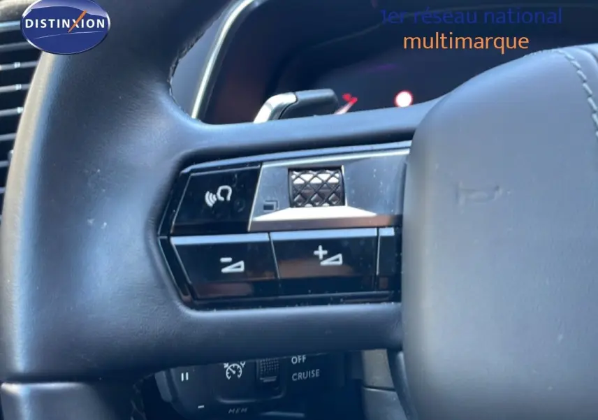 Gros plan sur le volant noir du DS7 2024, montrant les commandes audio et de régulateur de vitesse.