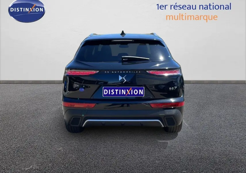 Vue arrière d'une DS7 noire métal 2024 avec feux LED effilés et logo DS centré sur un fond clair.