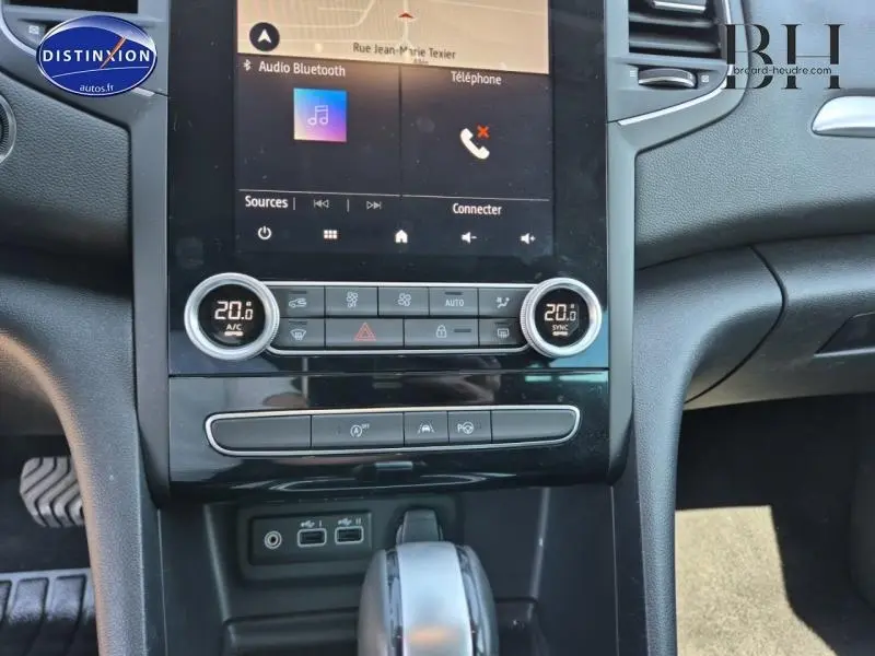 Gros plan sur la console centrale tactile et la commande de climatisation de la Renault Mégane Break gris Titanium 2024.