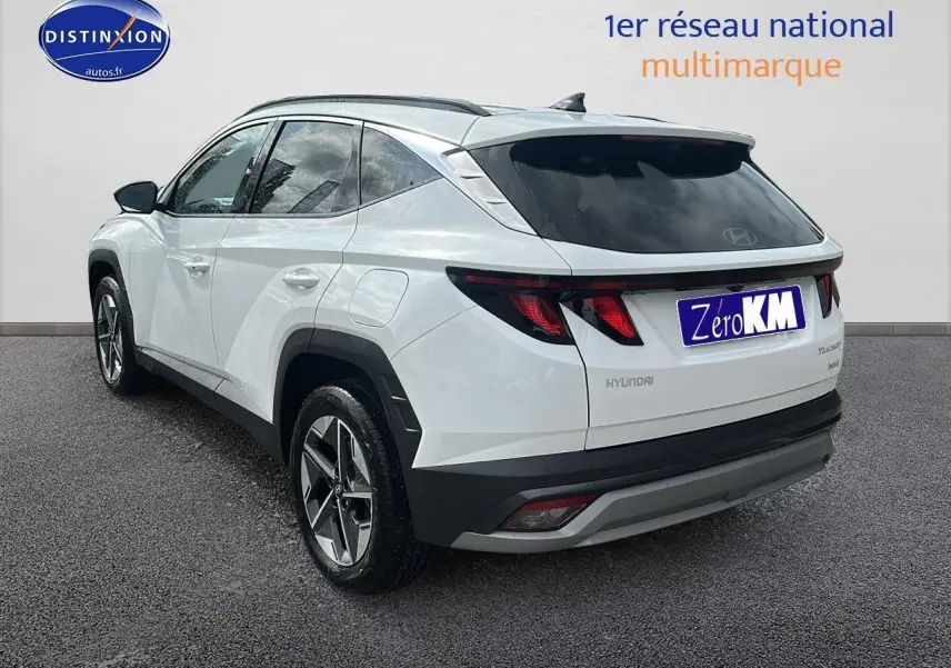 Vue 3/4 arrière droite d'un Hyundai Tucson blanc sérénité avec jantes alliage et vitres teintées.