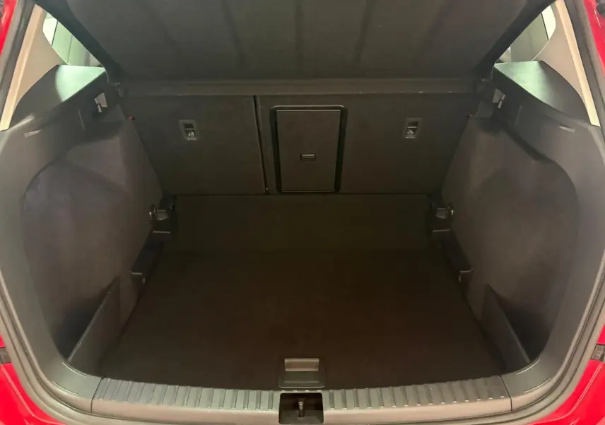 Coffre ouvert du SEAT Ateca Rouge Velvet 2024, montrant le plancher à double fond et l’espace de chargement vide.