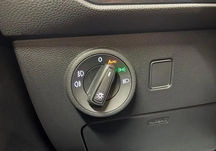 Détail du bouton de commande des phares sur le tableau de bord noir d’un SEAT Ateca 2024.